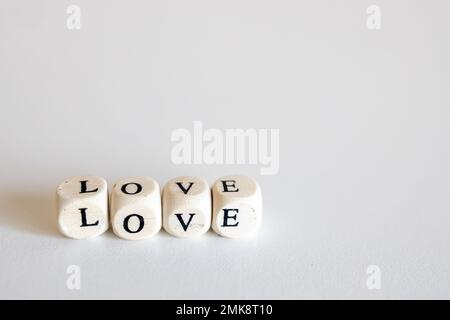 Word Love besteht aus Holzwürfeln, isoliert auf weißem Hintergrund Stockfoto