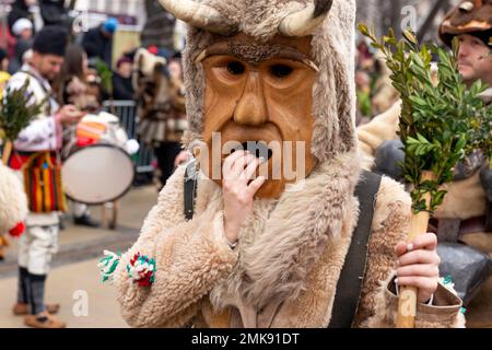 Pernik, Bulgarien. 28. Januar 2023 Weibliche Kukeri-Tänzerin mit großer Holzmaske beim Surva International Festival of Masquerade Games ist das größte Winterfestival in Europa und die beliebteste und maßgeblichste Manifestation traditioneller Volksspiele, Masken und Kostüme in Bulgarien. Dieses Jahr ist es die 29. Festival-Ausgabe, die drei ganze Tage lang mit mehr als 10 000 Teilnehmern aus ganz Europa abgehalten wird. Die Veranstaltung umfasst zahlreiche Konzerte und Workshops, Getränke- und Imbissstände und zieht Zehntausende von Zuschauern auf sich. Kredit: Ognyan Yosifov/Alamy Live News Stockfoto