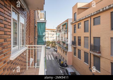 Gebäude mit Ziegelfassaden von einem schmalen Balkon mit weißen Metallgeländern aus gesehen Stockfoto