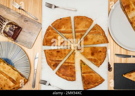 Große Scheiben galizischer Empanadas auf einem weißen Tisch Stockfoto