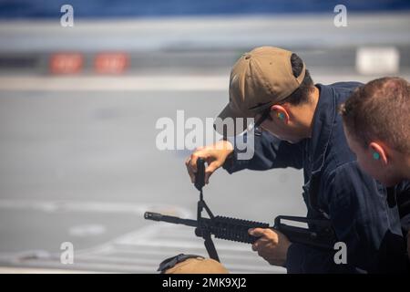 PHILIPPINISCHES MEER (Sept 7, 2022) – Gunners Mate Seaman Martin Aguayo aus Phoenix, Arizona, stellt während eines Schusses an Bord des Lenkraketen-Zerstörers USS Zumwalt (DDG 1000) in der philippinischen See am 7. September ein M4 Gewehr ein. Zumwalt führt laufende Operationen zur Unterstützung eines freien und offenen Indo-Pacific durch. Stockfoto