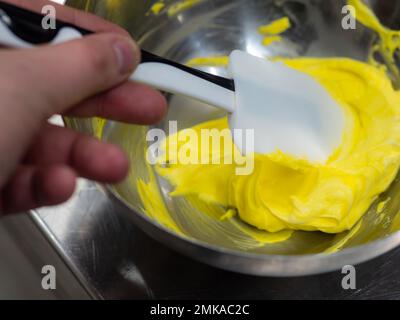 Gelbe Glasrohrfüllung für die Frostkuchendekoration im Küchenlabor Stockfoto