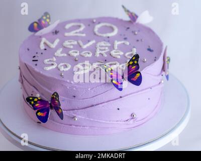 20 Jahre alter Milchkuchen, dekoriert mit einem cremefarbenen, handgemachten Satz, Schmetterlinge, Perlen, Streusel vom Bäckerdesigner Stockfoto