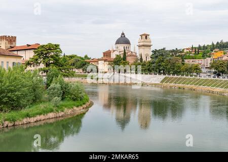 Blick auf einen ruhigen Fluss Fiume Adige in Richtung der Kirche Saint Giorgio am Flussufer in Verona Italien Stockfoto