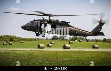 Ein Feld von Heuballen umrahmt einen Iowa Army National Guard UH-60 Black Hawk, der sich auf die Schlinge eines Anhängers während eines U.S. Pathfinder Course am 8. September 2022 in Camp Dodge in Johnston, Iowa, vorbereitet. Fast 30 Soldaten absolvierten den Kurs, der von einem mobilen Trainingsteam im Warrior Training Center der Army National Guard in Fort Benning, Georgia, unterrichtet wurde. Army Pathfinders werden geschult, um Navigationshilfe und Beratungsdienste für Militärflugzeuge in Gebieten zu leisten, die von unterstützten Einheiten-Kommandeuren bestimmt werden. Während des Pathfinder-Kurses werden die Studenten in der Flugzeugorientierung, Aero-Medical ev, unterwiesen Stockfoto