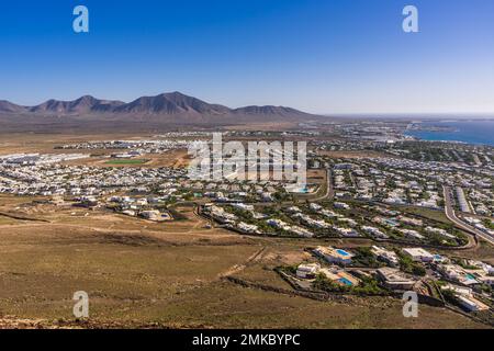 Blick auf Playa Blanca vom Kraterrand von Montana Roja mit Blick auf den Ferienort Playa Blanca auf Lanzarote. Stockfoto