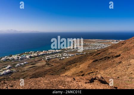 Mit Blick auf die Gegend um den Leuchtturm von Pechiguera, der sich an einem Ende der Playa Blanca in Lanzarote befindet. Über dem Meer die Vulkane von Fue Stockfoto