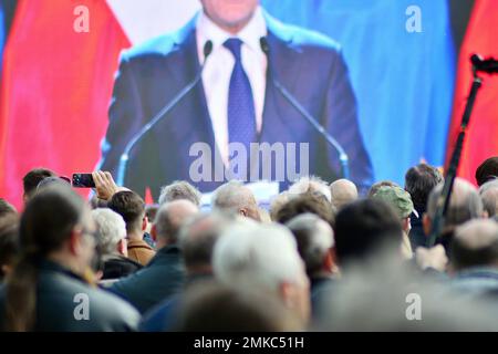 Die Menge nimmt an einem politischen Treffen Teil. Eine große Gruppe von Menschen als Zuschauer für die Rede eines Politikers im Freien auf der Großleinwand. Stockfoto