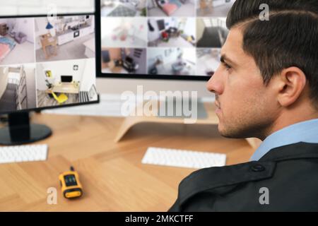 Männlicher Wachmann überwacht Kameras am Arbeitsplatz, Nahaufnahme Stockfoto