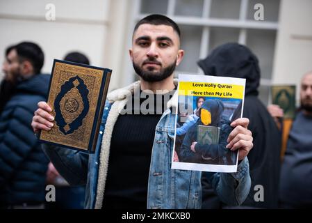 London, Großbritannien. 28. Januar 2023. Ein Demonstrant hält den Koran während der Demonstration gegen die Verbrennung des Korans in Schweden. Der hohe Vertreter der Allianz der Zivilisationen der Vereinten Nationen hat die Verbrennung des heiligen muslimischen Buches durch einen schwedisch-dänischen rechtsextremen Politiker als "abscheulichen Akt" verurteilt. Rasmus Paludan, Anführer der dänischen rechtsextremen politischen Partei Hard Line, führte am Freitag, den 27. Januar 2023 unter dem Schutz der örtlichen Polizei vor der türkischen Botschaft in Schweden die Aktion durch. Kredit: SOPA Images Limited/Alamy Live News Stockfoto