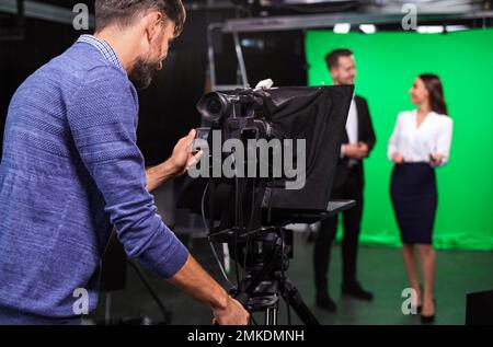 Referenten und Videokamerafirma, die im Studio arbeiten. Nachrichtenübertragung Stockfoto