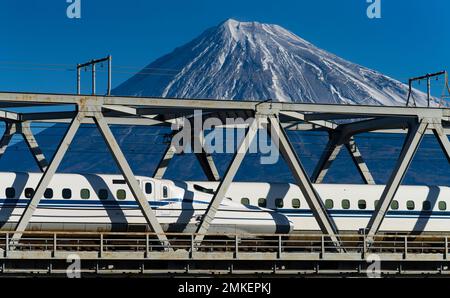 JR Central N700 Züge der Tokaido Shinkansen-Linie überqueren eine Brücke über den Fuji-Fluss (Fujikawa) mit dem Fuji-Berg in der Präfektur Shizuoka, ja Stockfoto