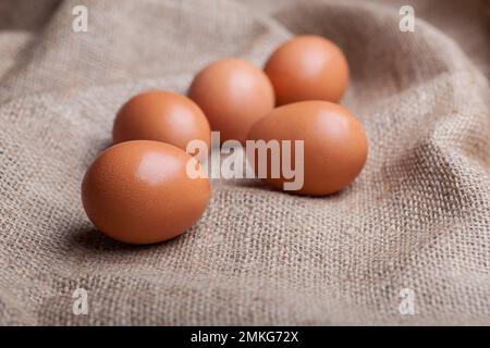 Frische Eier auf Säcken verstreut Stockfoto