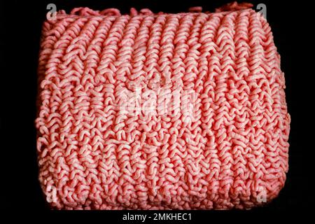 Ungekochtes rohes Rinderhack mit zerkleinerter Konsistenz. Stockfoto