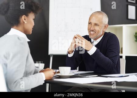 Sprechen wir über Ihren neuen Vertrag. Eine junge Geschäftsfrau, die sich mit ihrem Chef trifft. Stockfoto