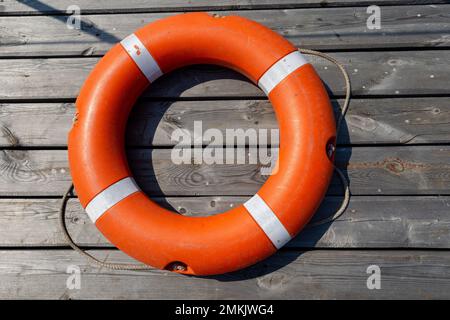 Das Rettungsboot liegt auf einem hölzernen Pier. Das Konzept der Ertrinkungsersparnis auf dem Wasser. Stockfoto