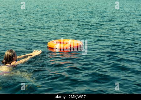 Eine Person im Wasser bekommt eine Rettungsleine, um zu helfen. Das Konzept der Rettung Ertrinken auf dem Wasser, Bewegungsunschärfe .. Stockfoto