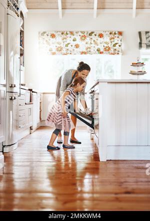 Füllt ihr Haus mit dem köstlichen Duft hausgemachter Backwaren. Ein kleines Mädchen, das mit ihrer Mutter in der Küche backt. Stockfoto