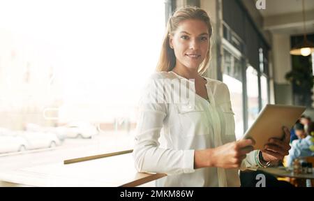 Wir alle brauchen einen Ort, wo wir allein sein können. Eine attraktive junge Frau in einem Café. Stockfoto