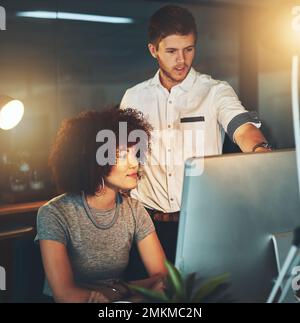 Austausch von Ideen. Junge Angestellte, die bis spät in die Nacht arbeiten. Stockfoto