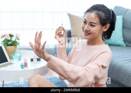 Die junge Dame trägt zu Hause Nagellack Stockfoto