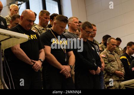 Task Force Dragon Mitglieder beugen ihre Köpfe als Kaplan (Col.) Thomas Helms, XVIII. Airborne Corps Chaplain, führt ein Gebet während einer Gedenkfeier 9/11 am 11. September 2022 in Wiesbaden, Deutschland. Die Zeremonie würdigte sowohl US-Militärmitglieder als auch Ersthelfer, die von den Terroranschlägen vom 11. September 2001 betroffen waren, und die Reaktion des Landes auf die Angriffe. Die Zeremonie würdigte auch das Leben von fast 3.000 Menschen, die während der Angriffe auf unsere Nation vom 11. September 2001 starben. Stockfoto