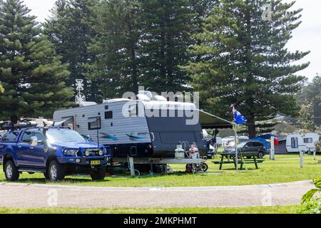 Australische Campingplätze, Campingplätze und Wohnmobile in Narrabeen in Sydney, Australier genießen Sommerferien im Park mit fliegenden Flaggen, Australien Stockfoto