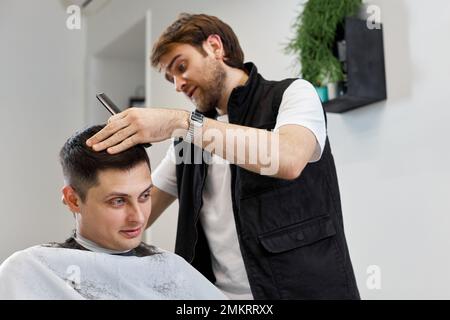 Friseur rasierender Weißer im Friseursalon. Stockfoto