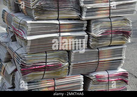 Deutschland April 2021: Ein Stapel Zeitungen auf dem Bürgersteig Stockfoto