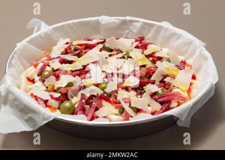 Frische hausgemachte italienische Pizza mit gebackenem Speck, Oliven, Kapern und Parmesan Stockfoto