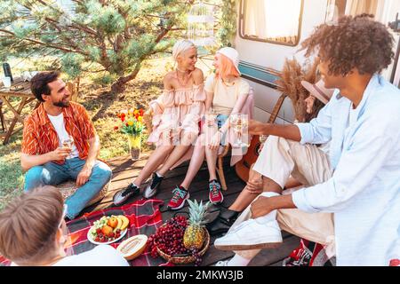 Eine Gruppe von Freunden picknicken an einem heißen Tag mit einem Camper Stockfoto