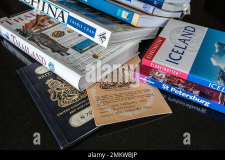 Alte britische Pässe und eine Reihe von Reiseführern oder Büchern. Umfasst China, Thailand, Island, Sri Lanka, Costa Rica, Moskau usw. Stockfoto