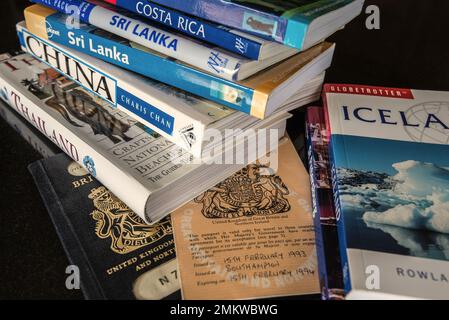 Alte britische Pässe und eine Reihe von Reiseführern oder Büchern. Umfasst China, Thailand, Island, Sri Lanka, Costa Rica, Moskau usw. Stockfoto