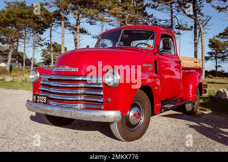 Vorderansicht eines alten roten Chevrolet 3100 Pickup Classic Car auf einem Parkplatz an der Küste von Dänemark, Djursland, Jütland. Stockfoto