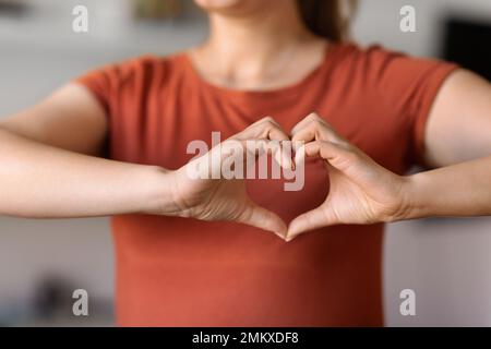 Unerkennbare Frau, Die Eine Herzgeste Macht, Mit Händen In Der Nähe Der Brust Stockfoto