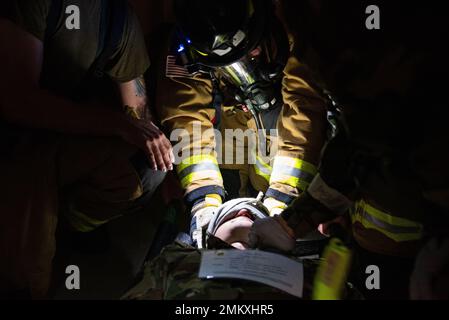 Feuerwehrleute, die der Zivilingenieursgeschwader von 51. zugewiesen wurden, behandeln einen simulierten verletzten Flugmann während eines Brandszenarios auf dem Luftwaffenstützpunkt Osan, Republik Korea, am 12. September 2022, zur Unterstützung einer Flügeltrainingsveranstaltung. Die Feuerwehrleute wurden auf ihre Fähigkeit getestet, verletzte Mitarbeiter während eines simulierten Feuers zu holen, zu behandeln und zu transportieren. Stockfoto