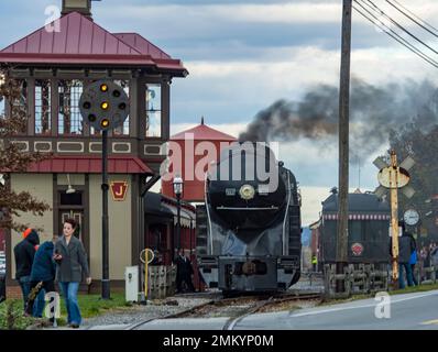 Strasburg, Pennsylvania, 13. November 2022 - Ein Blick auf eine große klassische Dampflok, die sich an einem bewölkten Herbsttag in einem Bahnhof bewegt Stockfoto