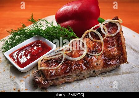 Gegrillte Schweinerippchen mit Zwiebeln, Barbecue-Sauce und Dill Stockfoto