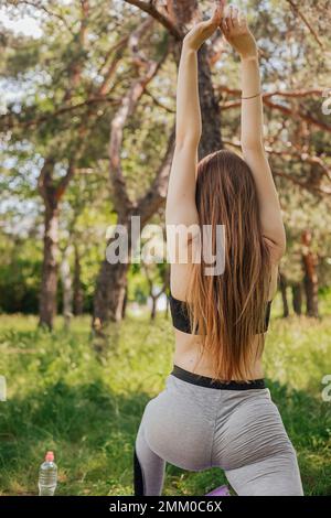 Yoga Frau auf grünem Gras Mädchen entspannt auf dem Feld. Yoga Frau im grünen Park Mädchen tun Gymnastik im Freien. Meditierende Frau in Meditation im Yoga p Stockfoto