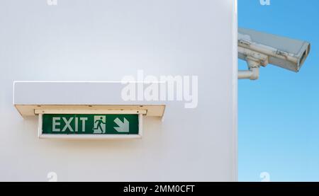 Notausgangsschild an der Wand mit Kamera im Hintergrund Stockfoto