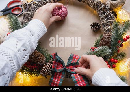 Einen Weihnachtskranz mit eigenen Händen machen. Feiertagsvorbereitung, Hausdekoration, Neujahr Stockfoto