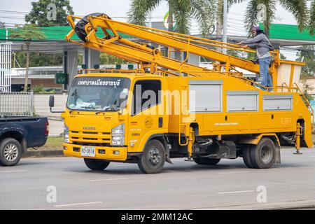 RATCHABURI, THAILAND, NOV. 16 2022, fährt Ein Lkw mit einer Hebebühne die Straße hinunter mit Arbeiter oben Stockfoto