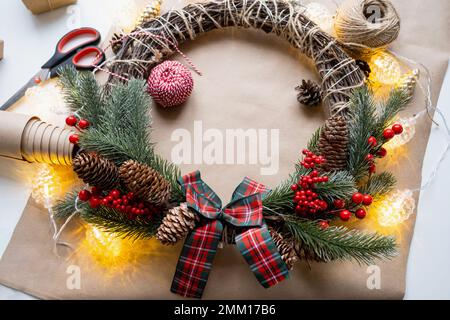 Einen Weihnachtskranz mit eigenen Händen machen. Feiertagsvorbereitung, Hausdekoration, Neujahr Stockfoto