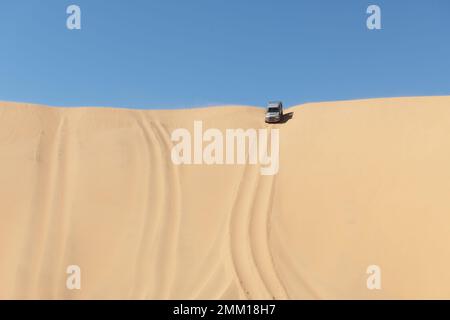 SUV-Fahrt über eine Sanddüne in der Namib-Wüste im Namib-Naukluft-Nationalpark in Namibia, Afrika. Landschaftsfotografie Stockfoto