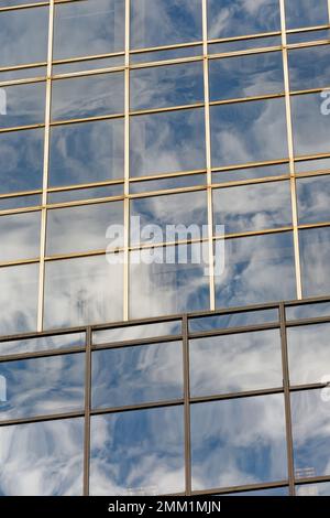 NYC: 420 Fifth Avenue spiegelt den Himmel in ihrem blau getönten Gittergitter wider; Schächte aus beigefarbenem Granit betonen die Höhe des 30-stöckigen Turms. Stockfoto