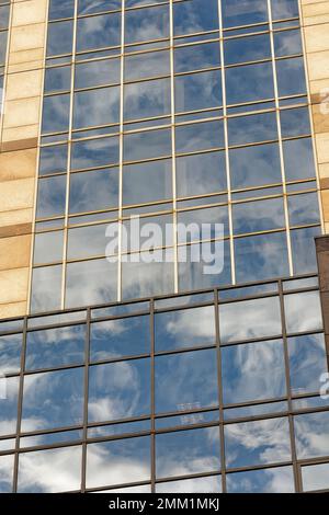 NYC: 420 Fifth Avenue spiegelt den Himmel in ihrem blau getönten Gittergitter wider; Schächte aus beigefarbenem Granit betonen die Höhe des 30-stöckigen Turms. Stockfoto