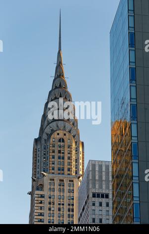 Am frühen Morgen bietet sich ein Blick auf das berühmte Chrysler Building von New York City. Der berühmte Art déco-Turm ist von der Sonne rot gesäumt. Stockfoto