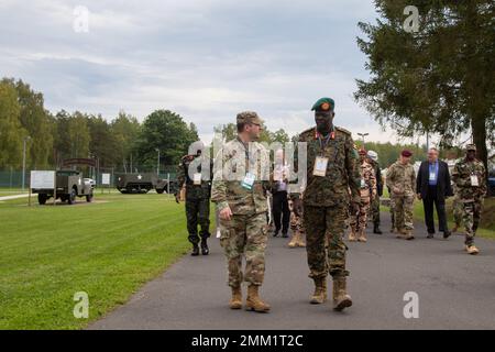 Brigadegeneral Bob Paciesky Ogiki, Stabschef der Landstreitkräfte Uganda, spricht mit Maj. Pat McGrath, auf dem Weg zum Restaurant, während des African Land Forces Colloquium 2022, Grafenwoehr, Deutschland, 13. September 2022. ALFC 22 brachte die Kommandeure der afrikanischen Landstreitkräfte zusammen mit ausgewählten US-Armeeanführern sowie Führern der alliierten und Partnerarmee, um die Sicherheitsherausforderungen der Landstreitkräfte anzugehen. ALFC22 betonte die institutionelle Ausbildung der US-Armee und die Möglichkeiten, „zu trainieren, um zu kämpfen“. Stockfoto