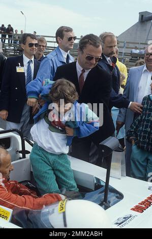 Carl XVI Gustaf, König von Schweden. Geboren am 30. april 1946. Der König Carl XVI Gustaf hilft seinem Sohn Prinz Carl Philip in einem Rennwagen 1986 Stockfoto