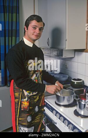 Carl XVI Gustaf, König von Schweden. Geboren am 30. april 1946. Als Kronprinz in seiner Studentenwohnung und Küche, während er in Uppsala studiert. Er steht neben dem Küchenherd und trägt eine Schürze und gibt vor, etwas zu kochen, aber es gibt kein Essen im Kochtopf. 1968 Stockfoto
